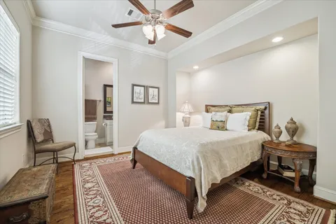 a spacious bedroom with a bed a couch and a large window