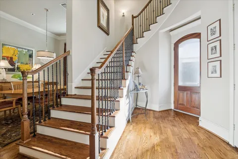 a view of staircase with lots of frames on wall and wooden floor