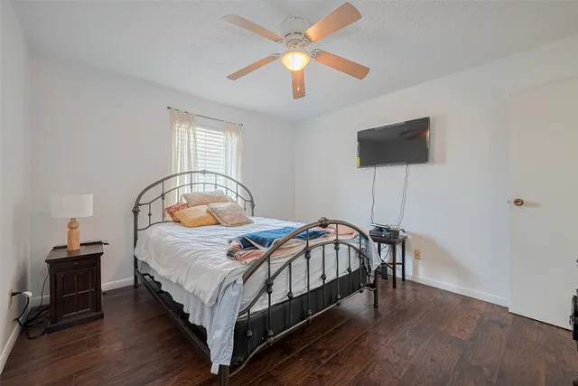 a bedroom with a bed a flat screen tv and a chandelier