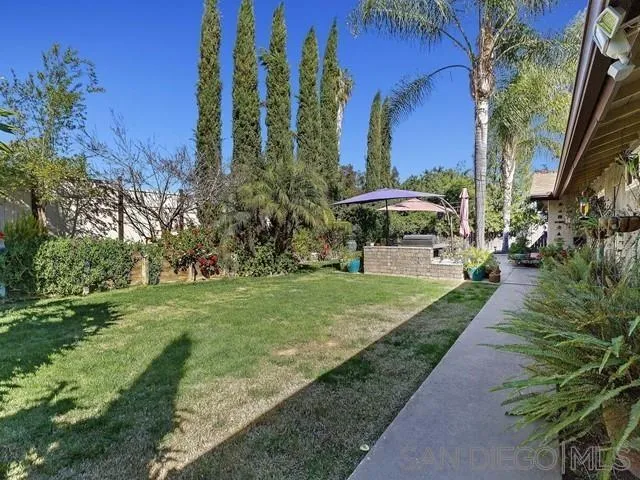 1528 Reche Road Fallbrook, CA 92028 - Photo 24 of 32 a view of a garden with a bench under an umbrella