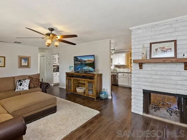 1528 Reche Road Fallbrook, CA 92028 - Photo 6 of 32 a living room with furniture a fireplace and a flat screen tv