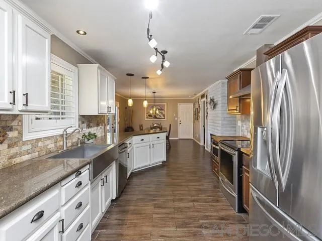 1528 Reche Road Fallbrook, CA 92028 - Photo 9 of 32 a large kitchen with stainless steel appliances granite countertop a lot of counter space and wooden floors
