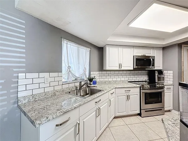 a kitchen with stainless steel appliances granite countertop a sink and a refrigerator