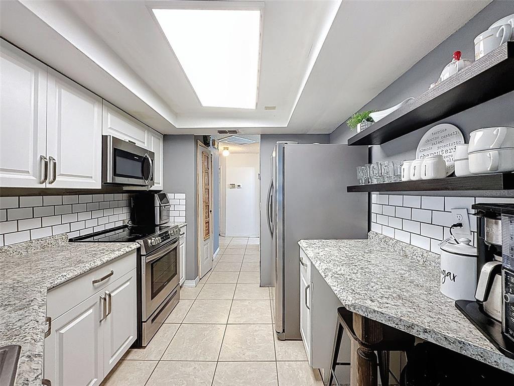 Undisclosed Address Spring Hill, FL 34608 - Photo 13 of 54 a kitchen with stainless steel appliances granite countertop a sink a stove and cabinets