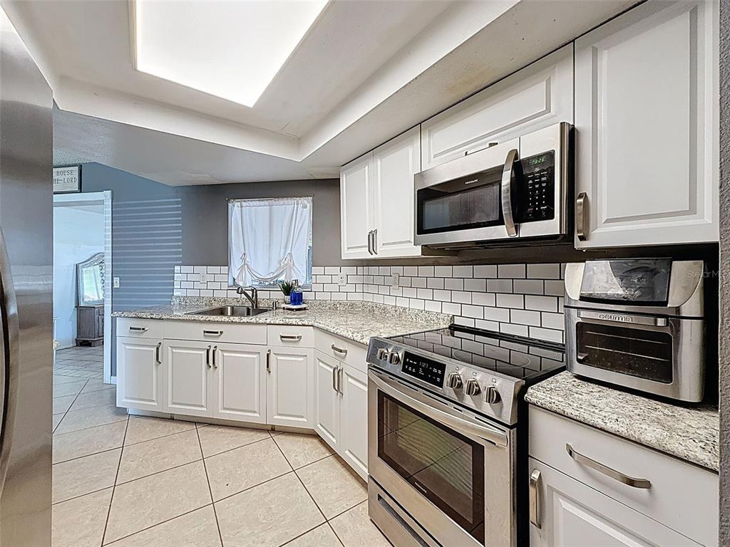 Undisclosed Address Spring Hill, FL 34608 - Photo 15 of 54 a kitchen with granite countertop cabinets stainless steel appliances and a counter space