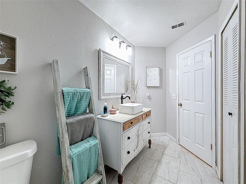 Undisclosed Address Spring Hill, FL 34608 - Photo 21 of 54 a spacious bathroom with a toilet sink and mirror