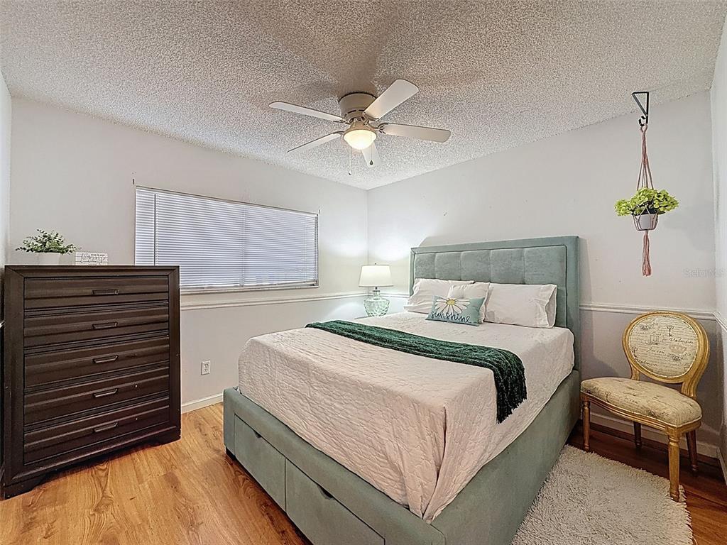 Undisclosed Address Spring Hill, FL 34608 - Photo 22 of 54 a bedroom with bed and a chandelier