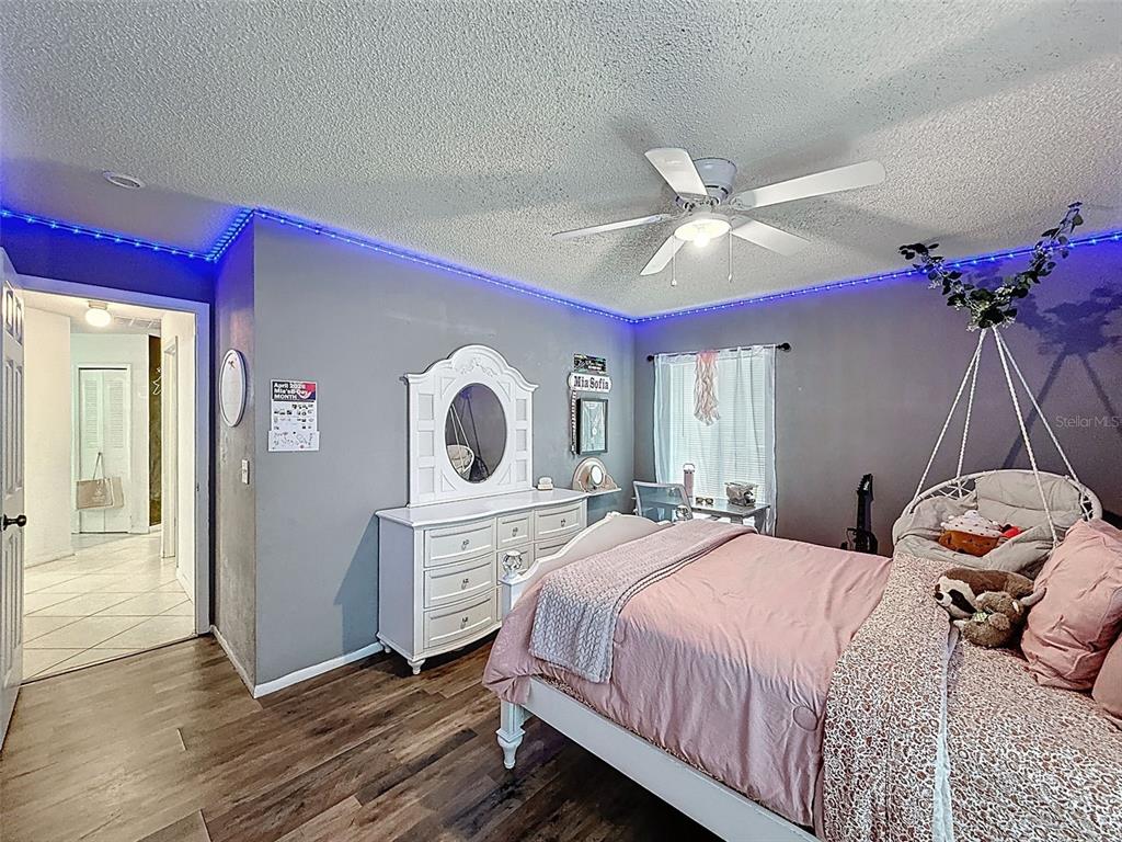 Undisclosed Address Spring Hill, FL 34608 - Photo 24 of 54 a bedroom with a bed and a chandelier