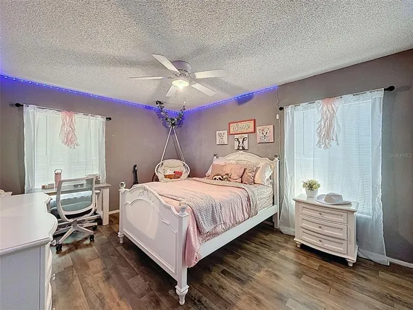 a bedroom with a bed and a flat tv screen on dresser