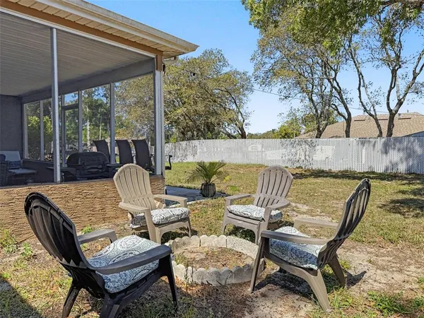a view of a house with a yard and a large tree