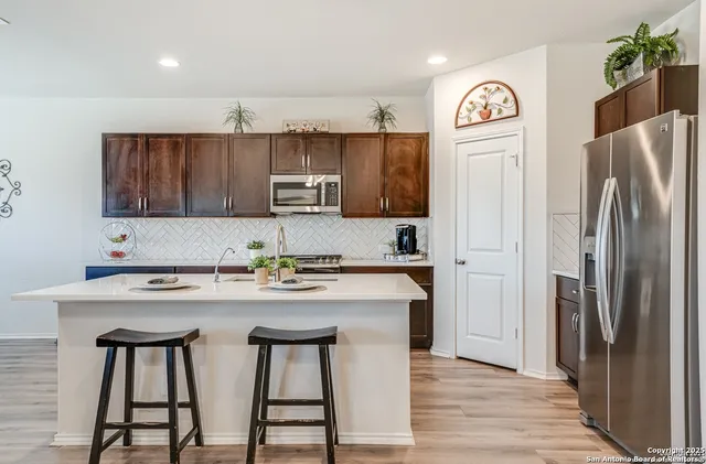 a kitchen with stainless steel appliances cabinets a sink and a refrigerator