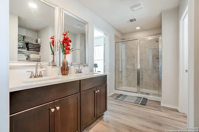a bathroom with a shower sink vanity granite and mirror