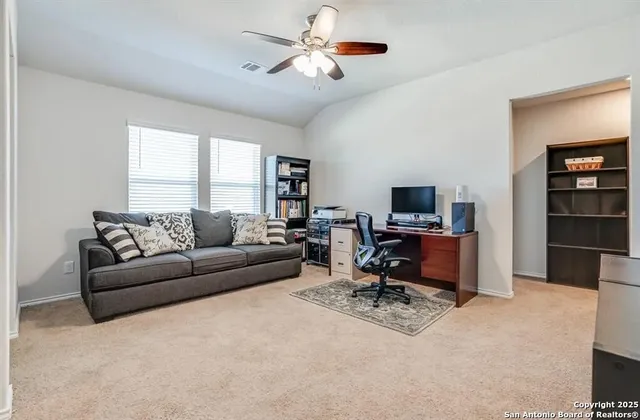 a view of a livingroom with workspace and a window