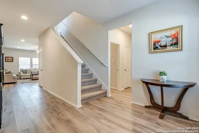 a view of a hallway with wooden floor and furniture