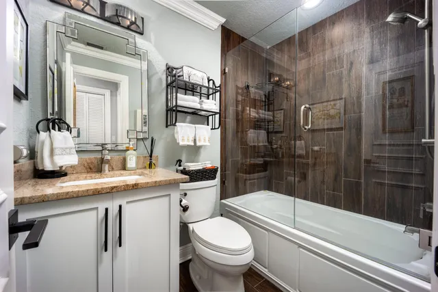 a bathroom with a granite countertop sink toilet and shower