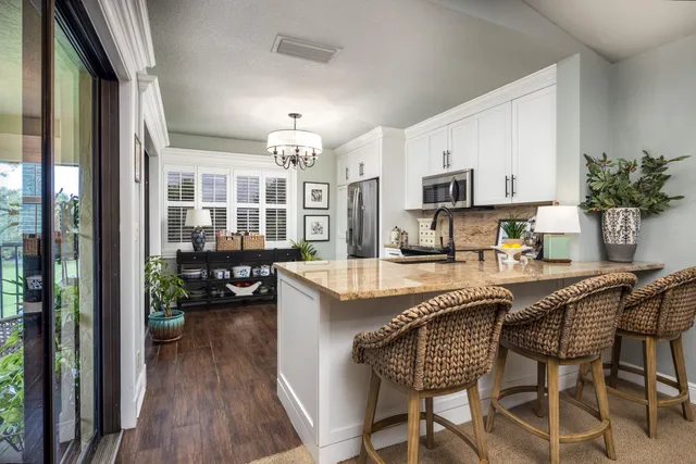 a kitchen with a table chairs refrigerator and cabinets