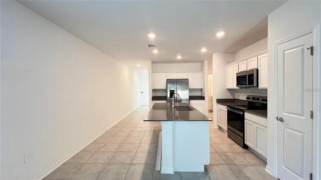 a kitchen with stainless steel appliances a sink a stove top oven a counter space and cabinets
