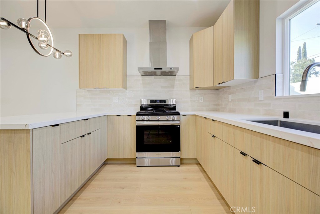 2242 North Keystone Street Burbank, CA 91504 - Photo 8 of 26 a kitchen with white cabinets and a stove