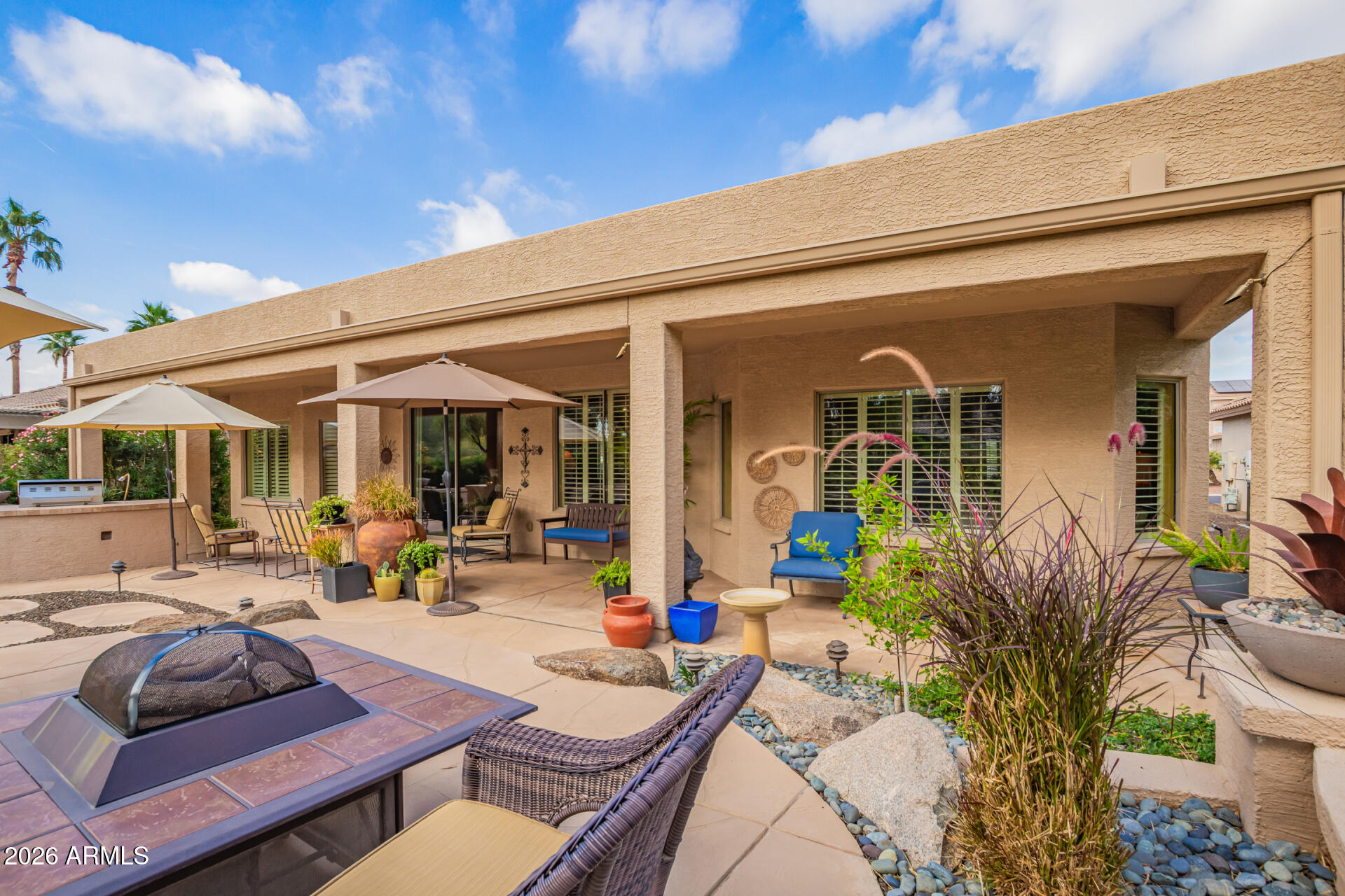 16287 West Cheery Lynn Road Goodyear, AZ 85395 - Photo 29 of 44 a view of a patio with table and chairs potted plants and floor to ceiling window
