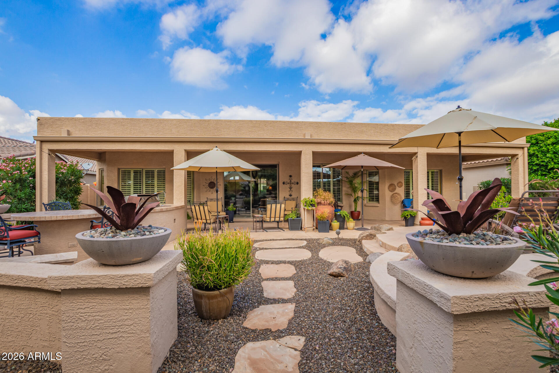 16287 West Cheery Lynn Road Goodyear, AZ 85395 - Photo 30 of 44 a view of a patio with dining table and chairs potted plants