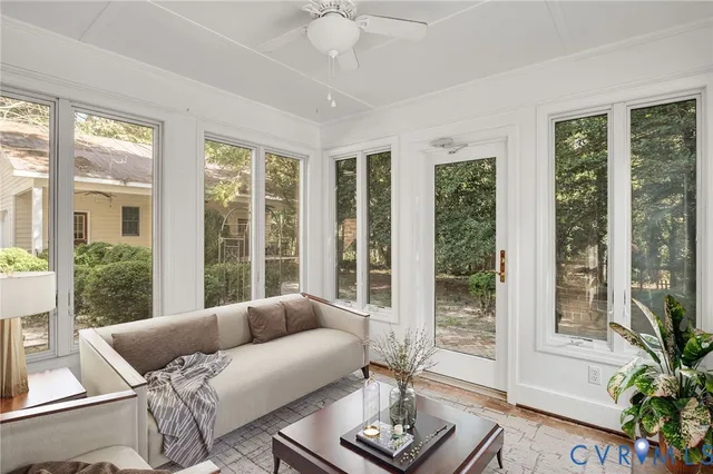 a living room with furniture and floor to ceiling windows