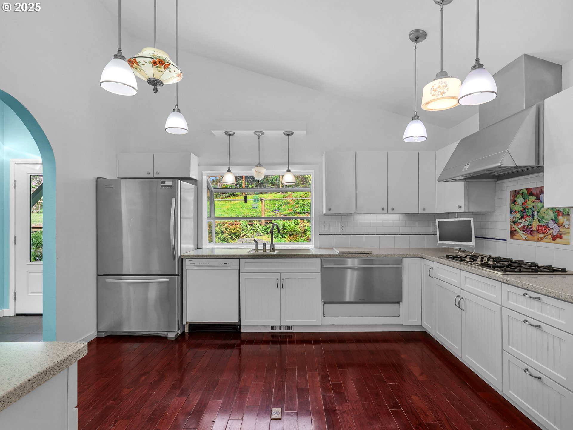 343 Hemlock Street Seaside, OR 97138 - Photo 5 of 17 a kitchen with stainless steel appliances granite countertop a refrigerator a sink dishwasher a dining table and chairs with wooden floor