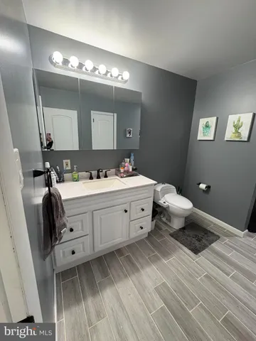 a bedroom with a bed and a flat tv screen on dresser