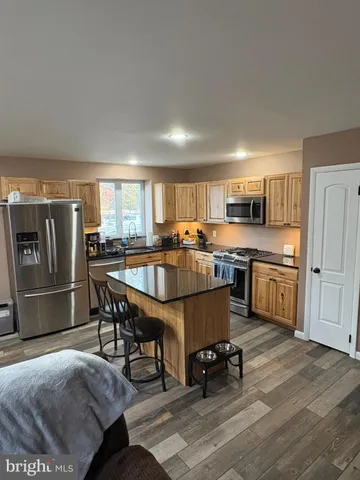 a kitchen with a table chairs microwave and refrigerator