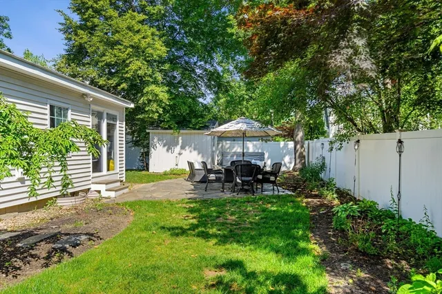 a view of a patio with table and chairs under an umbrella