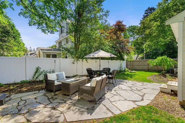 a view of a house with backyard and a tree