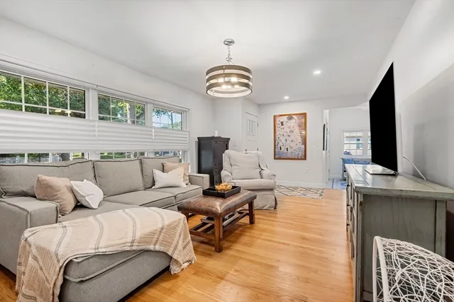 a living room with furniture a flat screen tv and a large window
