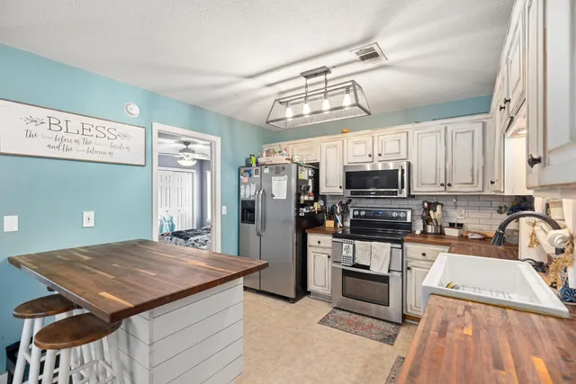 a kitchen with stainless steel appliances granite countertop a sink a stove and refrigerator