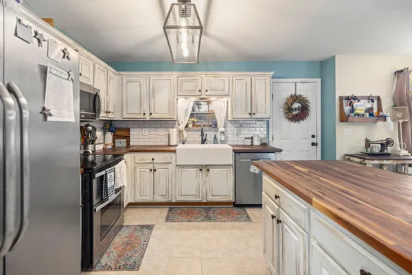 a kitchen with appliances a sink and cabinets