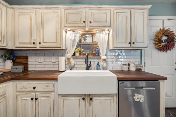 a kitchen with a stove a refrigerator a sink dishwasher with a dining table and chairs