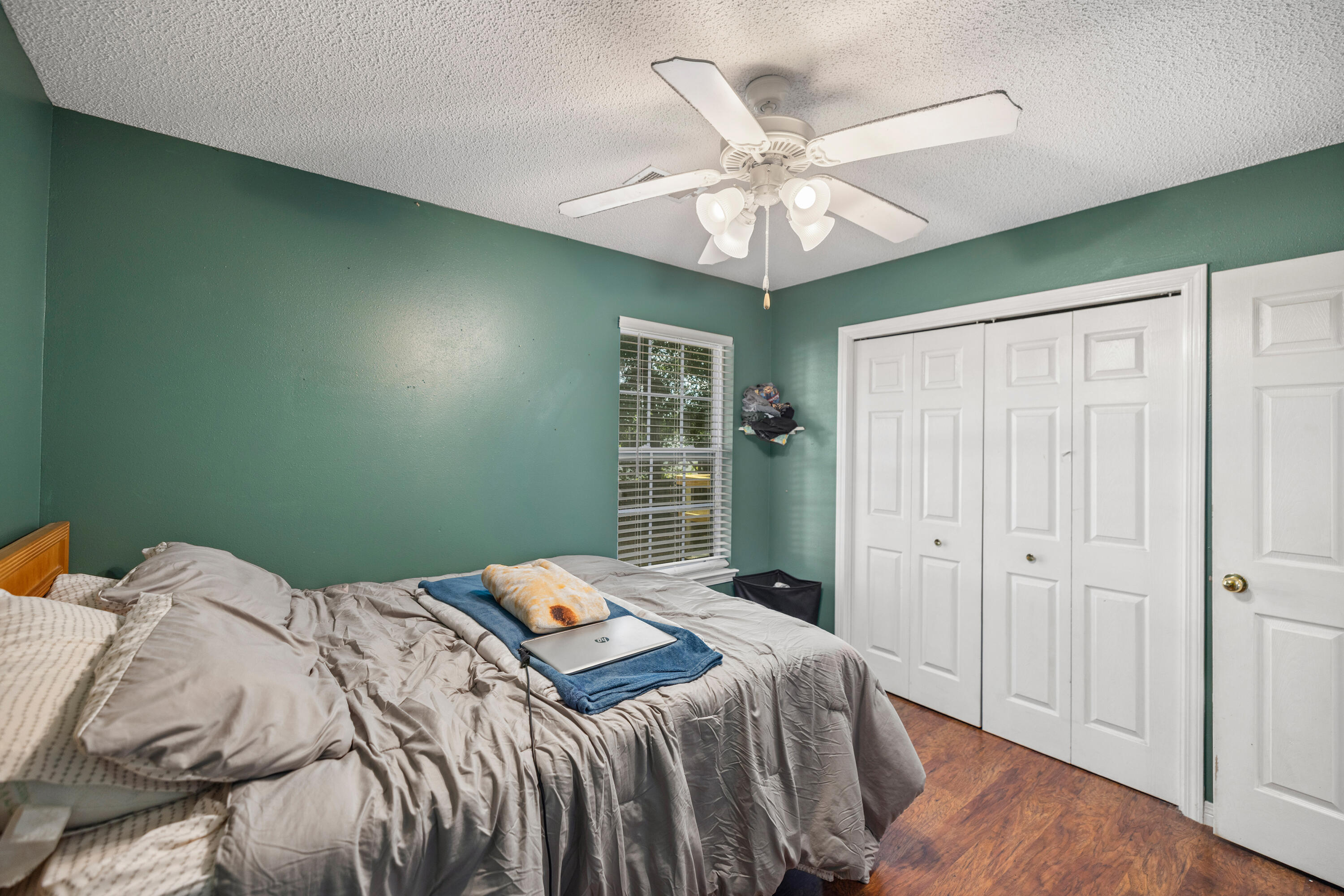 204 Warrior Street Crestview, FL 32536 - Photo 25 of 58 a bedroom with a large bed and a chandelier