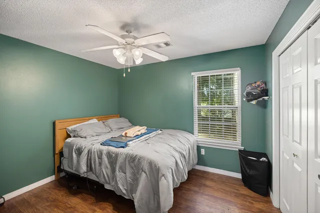 a bedroom with a large bed and a chandelier