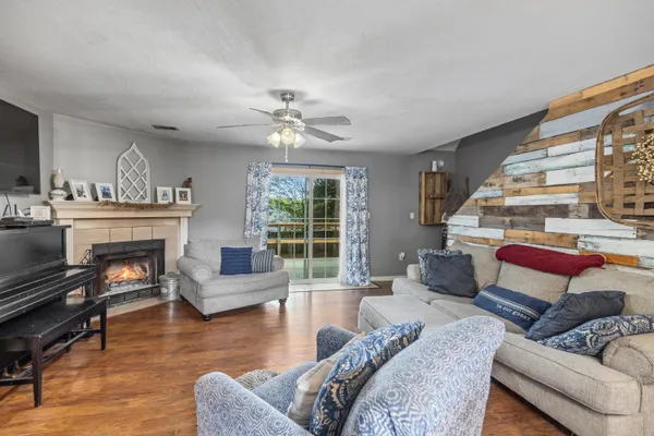 a living room with furniture kitchen view and a chandelier