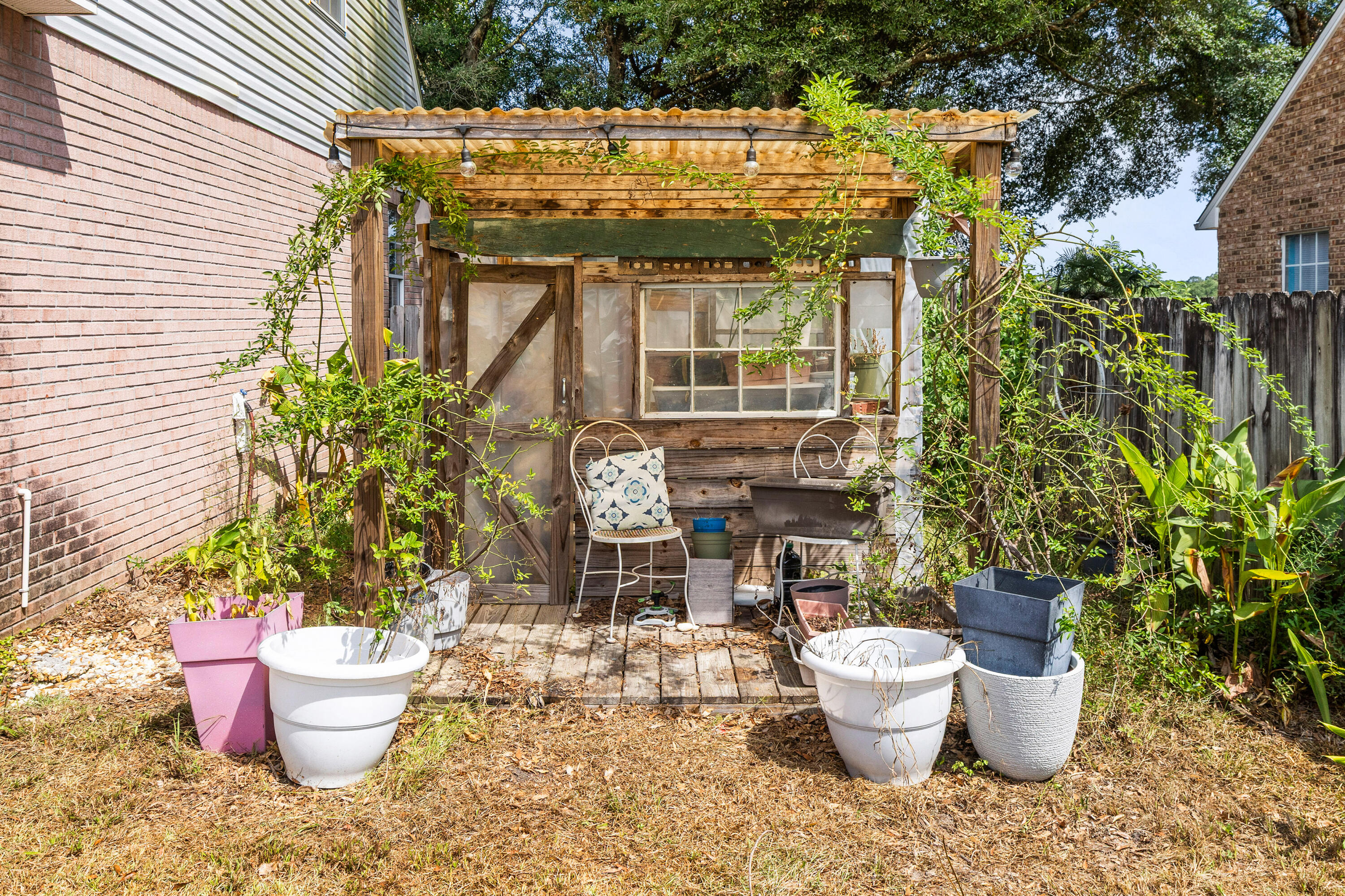 204 Warrior Street Crestview, FL 32536 - Photo 48 of 59 a view of a backyard with table and potted plants