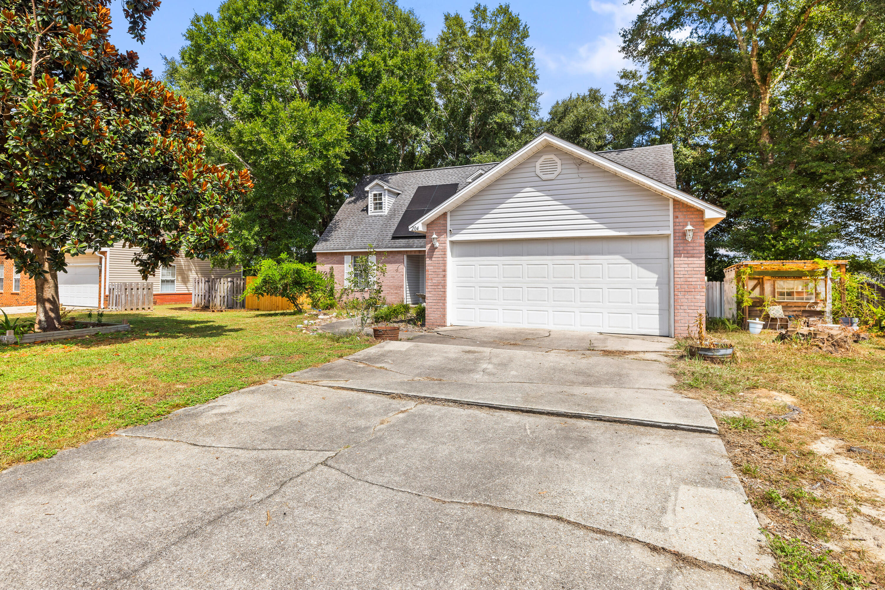204 Warrior Street Crestview, FL 32536 - Photo 50 of 58 a view of a house with a yard plants and large tree