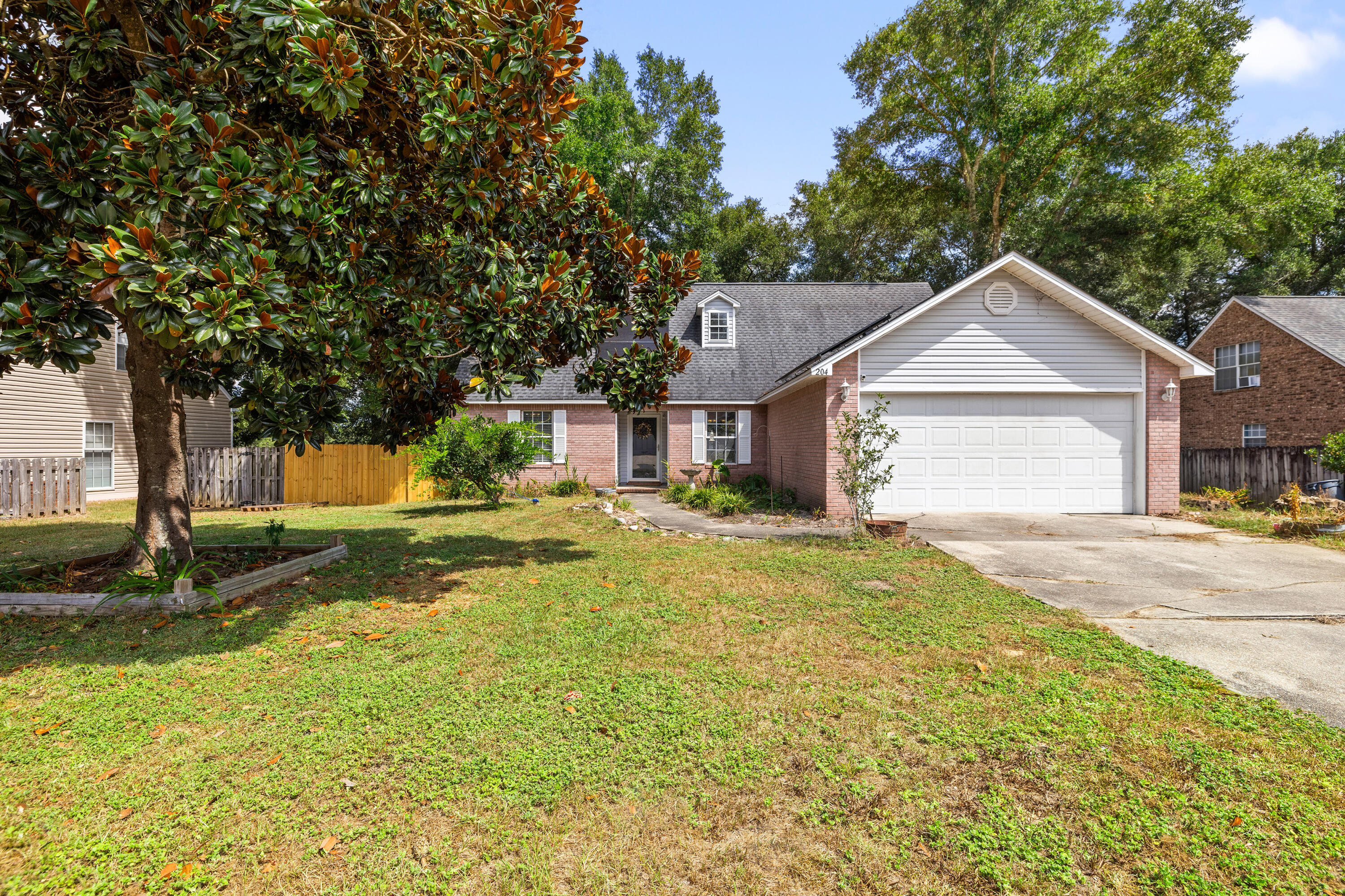 204 Warrior Street Crestview, FL 32536 - Photo 57 of 58 a front view of a house with garden