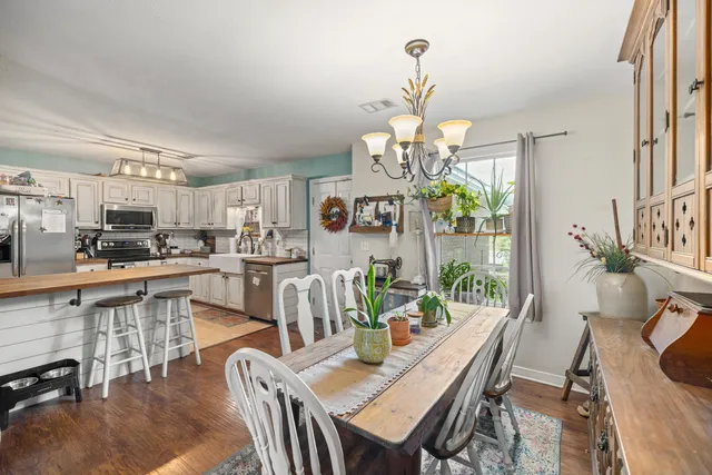 a view of a dining room with furniture a chandelier and wooden floor