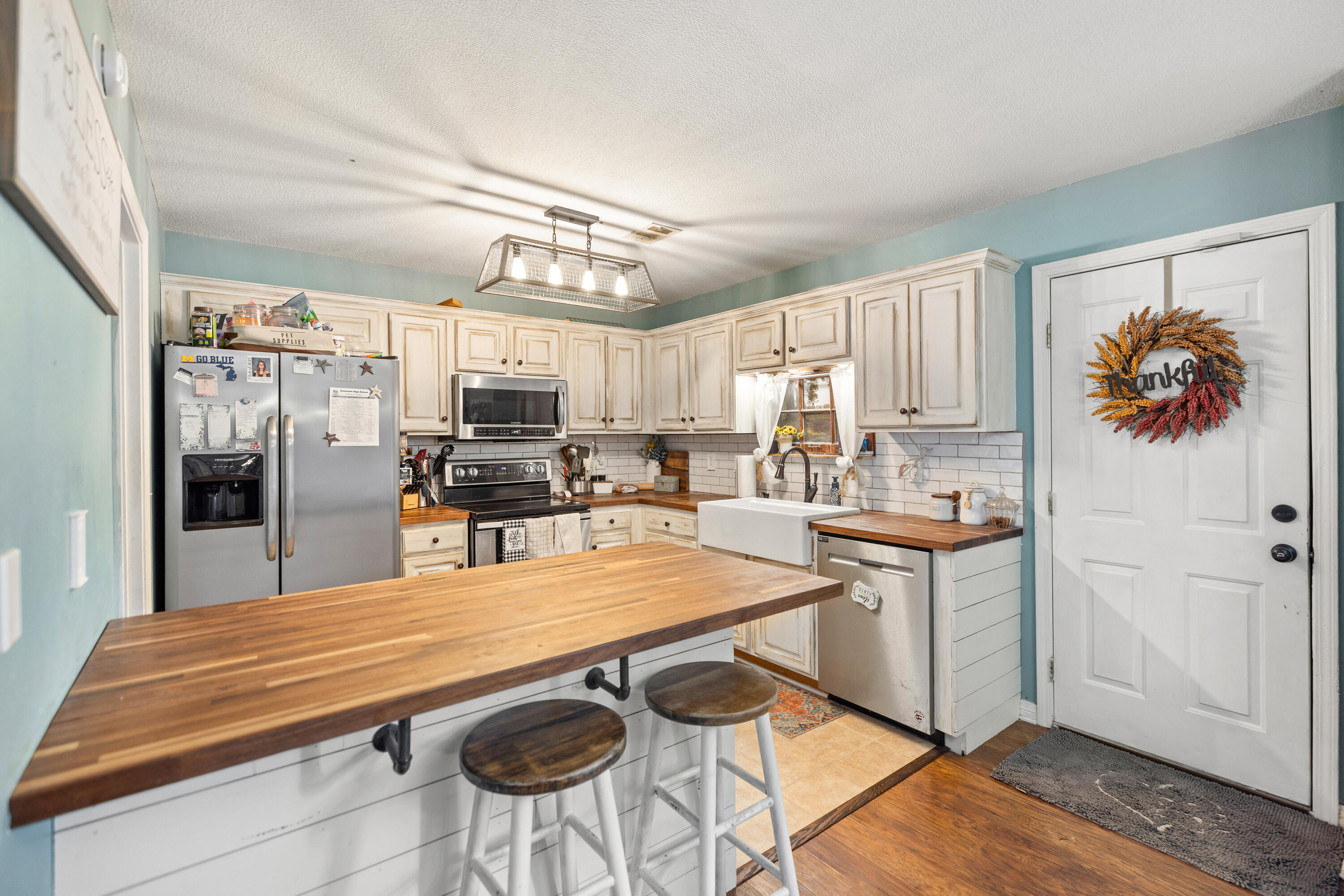 204 Warrior Street Crestview, FL 32536 - Photo 9 of 58 a kitchen with stainless steel appliances granite countertop a sink a stove a refrigerator cabinets and living room view