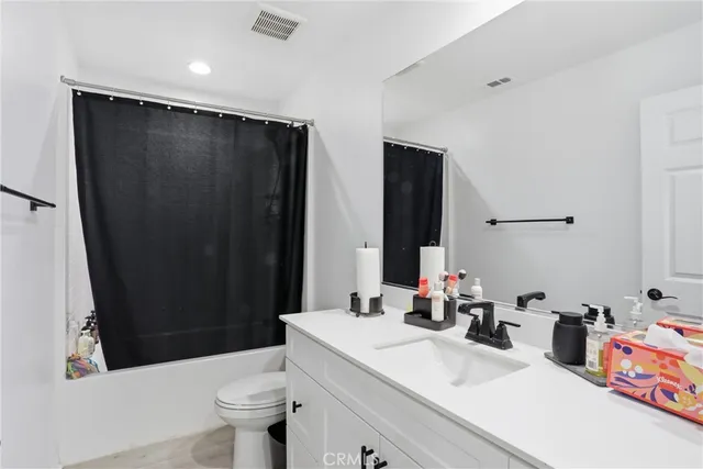 a bed sitting in a spacious bedroom next to a window