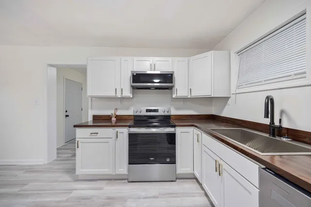 a kitchen with stainless steel appliances granite countertop a sink stove and cabinets