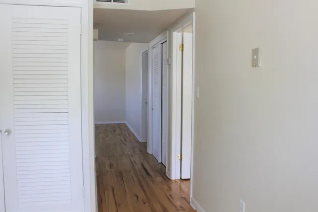 an empty room with wooden floor and a window