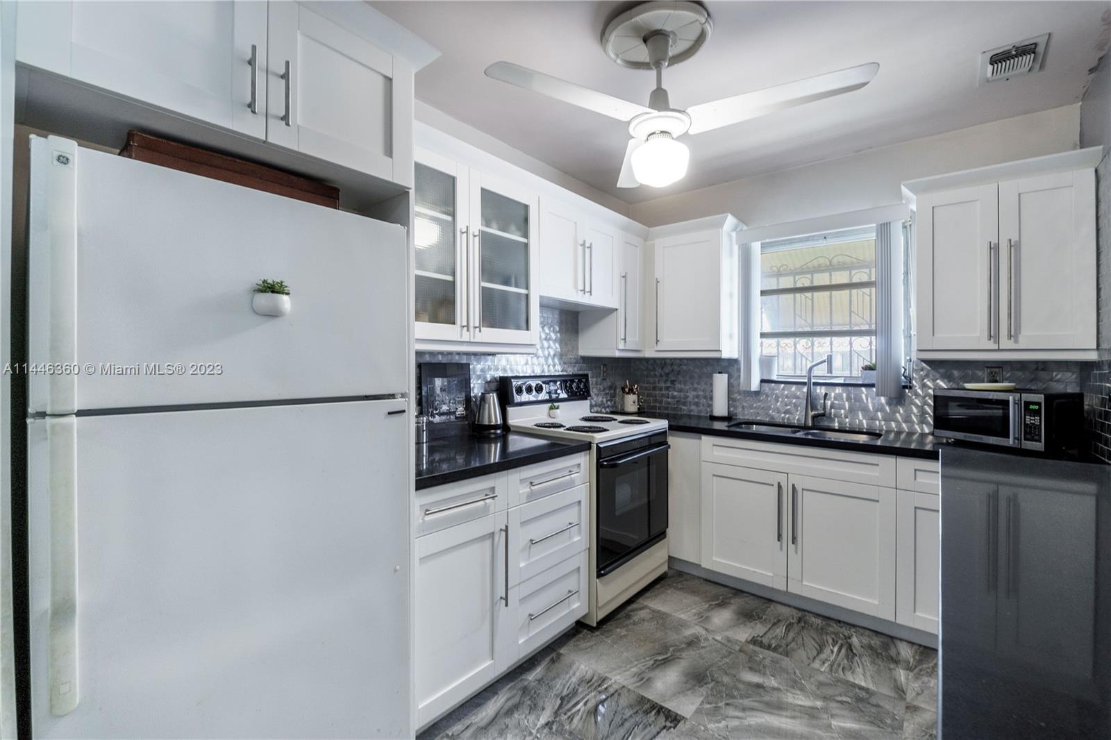 2446 Southwest 15th Street Miami, FL 33145 - Photo 12 of 42 a kitchen with stainless steel appliances granite countertop a stove a refrigerator and a sink