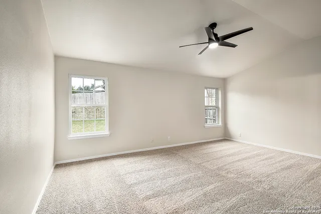 a view of a livingroom with a ceiling fan & entryway