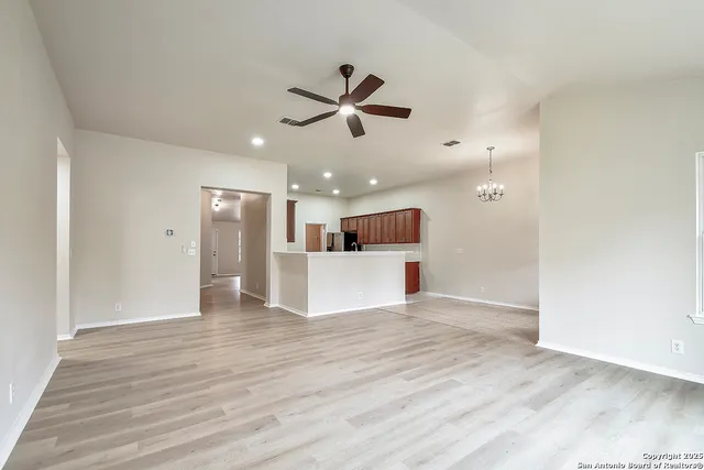 a view of a livingroom with a ceiling fan and wooden floor