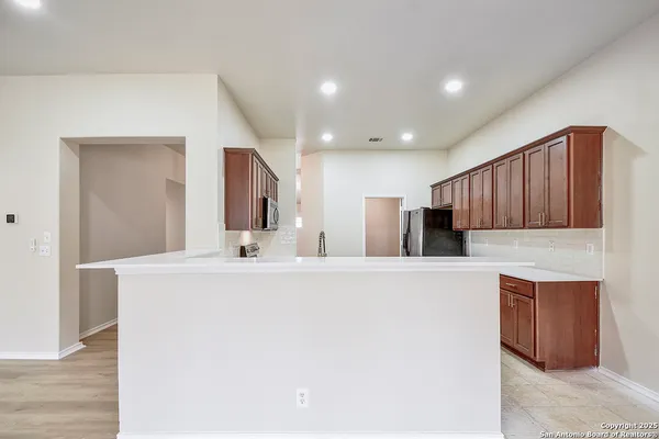 a kitchen with stainless steel appliances granite countertop a refrigerator sink and stove