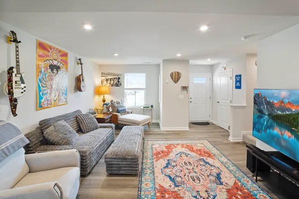 a kitchen with stainless steel appliances kitchen island granite countertop a refrigerator a stove and a sink with wooden floor